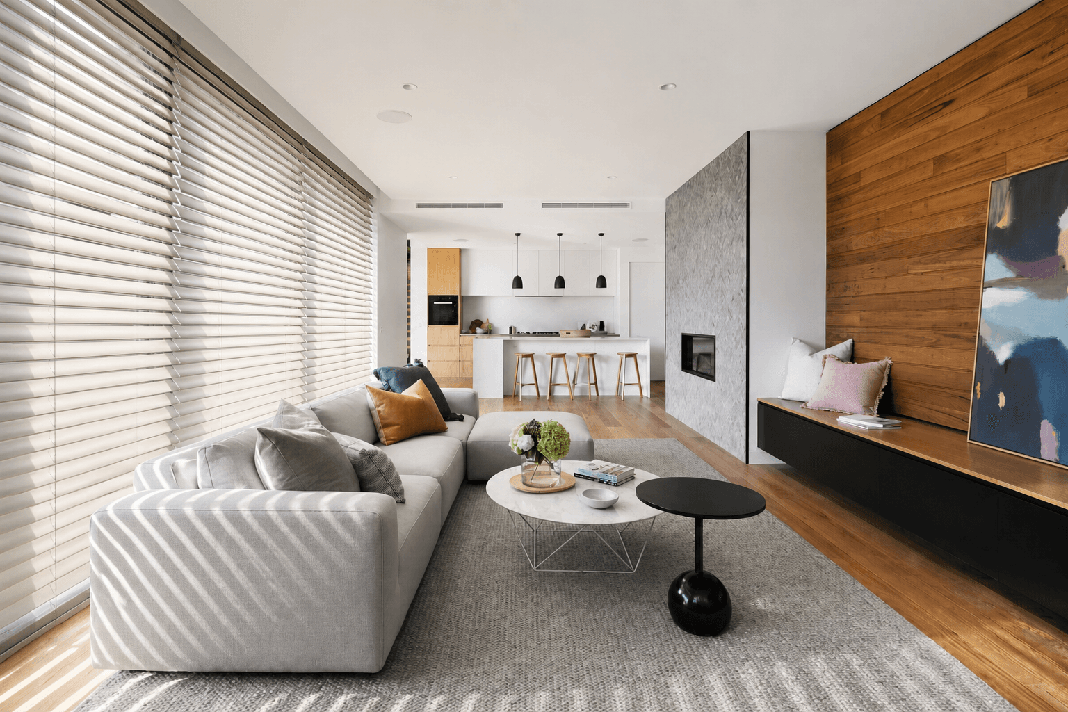 Living room with off-white 2-inch faux wood blinds and slat light